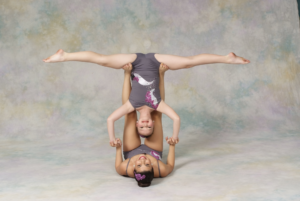 A dancer doing a split upside down while being based by another dancer