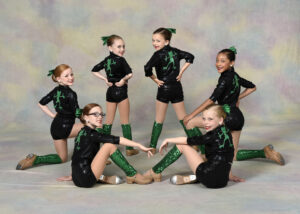 A small group of young dancers wearing tap shoes