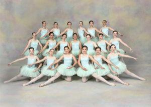 A group of ballet dancers smiling at the camera