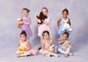 Six young dancers posing with stuffed animals.